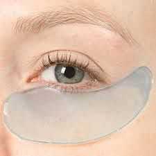 Gel eye patch applied under an eye on smooth, fair skin for skincare treatment.
