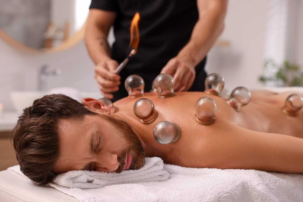 Man receiving cupping therapy with flame on back.