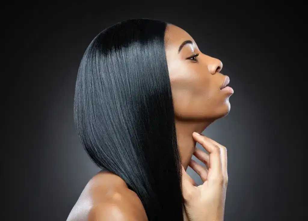 Profile of a woman with sleek, straight black hair against a dark background.