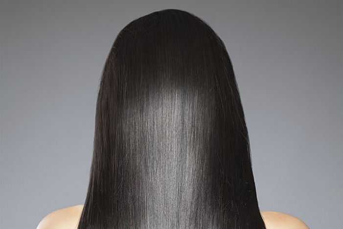 Woman with long straight black hair, back to the camera.