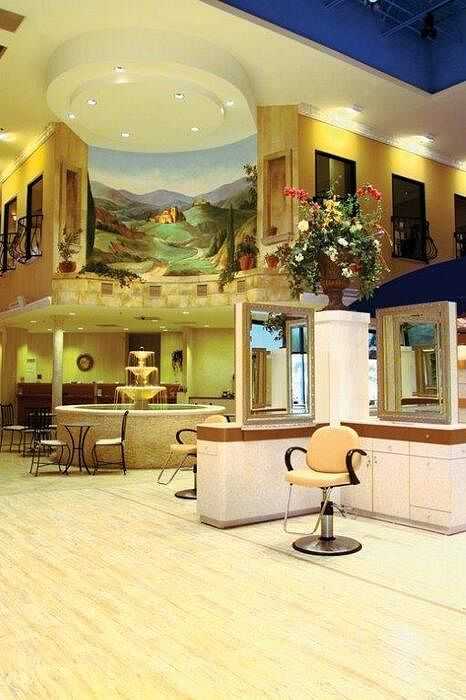 Elegant salon interior with murals, styling chairs, and a reception desk.