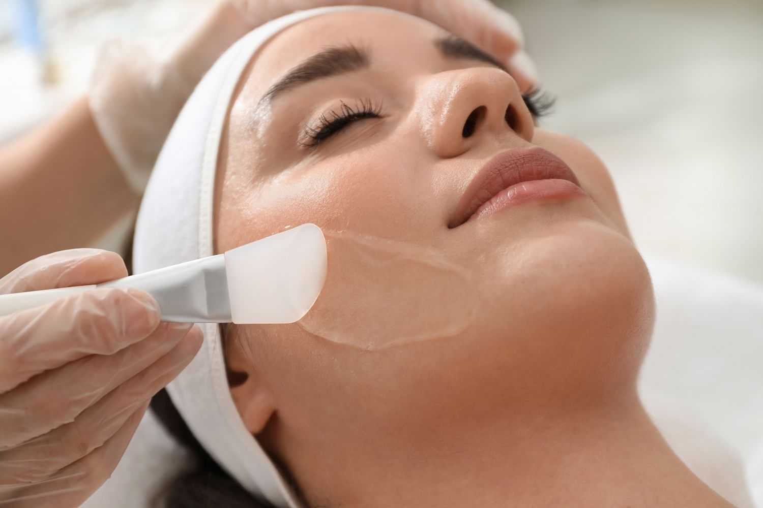 Woman receiving a facial treatment with a spatula.