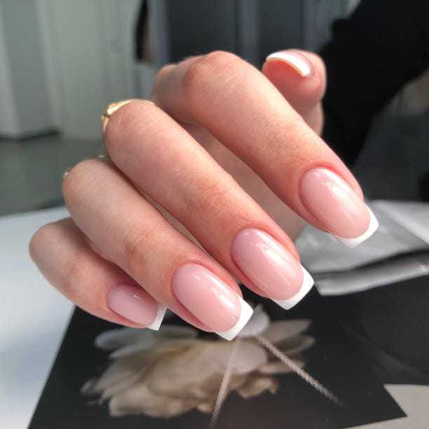 Elegant French manicure on neatly groomed nails.